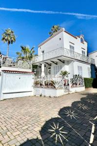 a white house with a fence and palm trees at Villa Solaris in Sanremo