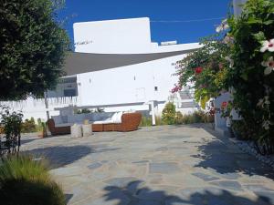 a patio with couches and flowers in front of a building at Melissa in Naousa
