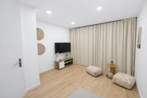 a living room with a flat screen tv and two chairs at Maison Connectée Serenia in Méru