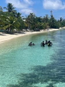 a group of people in the water near the beach at Island Scuba in Dhangethi