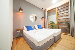 a bedroom with a bed with white sheets and blue pillows at Island Scuba in Dhangethi
