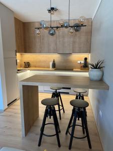 a kitchen with a island with three bar stools at ApartmanBrezovina217 in Veselé +24 photos