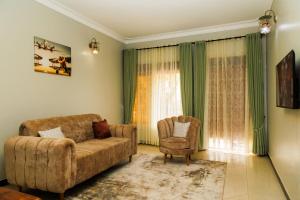 a living room with a couch and a chair at Palm Haven Furnished Apartments in Bweyogerere