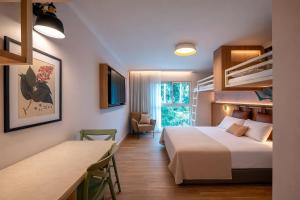 a hotel room with two beds and a table and a desk at Keshet Yehonatan Country Lodging in Keshet +42 photos