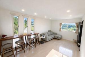 a living room with a table and chairs and a couch at Saraswati in Nakijin +42 photos