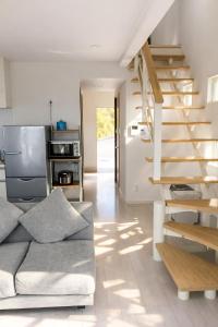 a living room with a couch and a staircase at Saraswati in Nakijin