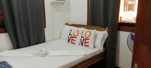 a small bed with a sign that says at Mangas Residents shared room in El Nido Airport