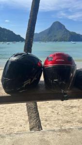 two helmets are sitting on a table on the beach at Mangas Residents shared room in El Nido Airport