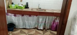 a bathroom with a sink and a shower curtain at Mangas Residents shared room in El Nido Airport