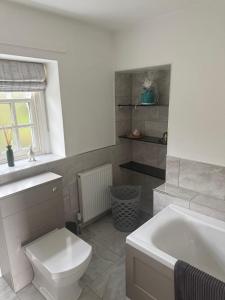 a bathroom with a toilet and a sink and a tub at West Cottage, Free Breakfast supplied with free range eggs With log burner in Towton +11 photos