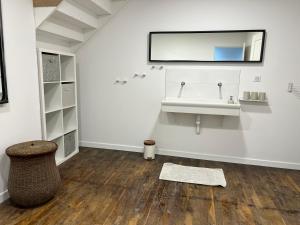 a bathroom with a sink and a mirror on the wall at Le Lido Maison 6 personnes in Saint-Varent