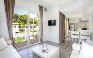 a living room with a white couch and a table at Camping Village Baia Azzurra in Castiglione della Pescaia