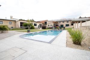 a swimming pool in a yard with houses at Rebenhof Schwalm in Herrnbaumgarten