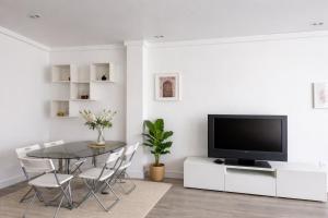 a dining room with a table and a tv at Zena Park - Near Lisbon in Odivelas