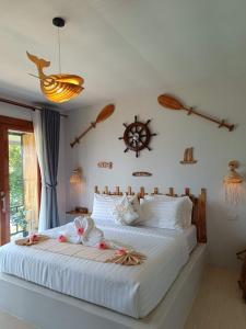 a bedroom with a large white bed with flowers on it at Marine House Koh Tao in Ko Tao