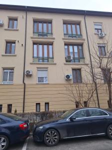 two cars parked in front of a building at Apartment Zona 0 Tulcea in Tulcea