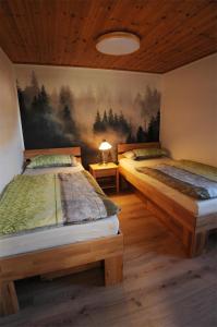 two beds in a room with a painting on the wall at Holzhaus im Schwedenstil in Scharnhorst