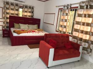 a bedroom with a bed and a couch and a chair at Alberjah Hotel in Atimpoko