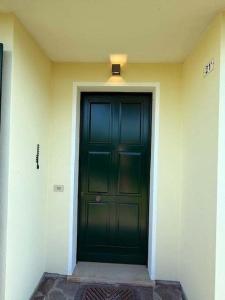 a green door in a building with a light above it at Adria in Isola Albarella +9 photos