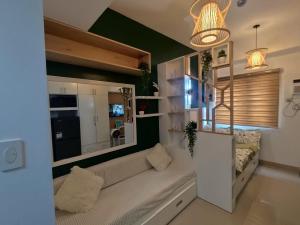a living room with a couch and a large window at Naomi's Green Haven in Dasmariñas