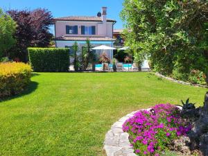 a house with a garden with flowers in the yard at Belvedere in Isola Albarella