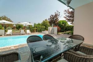 a dining table and chairs next to a swimming pool at Belvedere in Isola Albarella