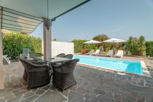 a patio with a table and chairs next to a pool at Belvedere in Isola Albarella