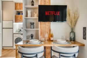 a kitchen with a table with a netflix sign above it at Modern City Studio with Balcony Columbus Apartment in Chios