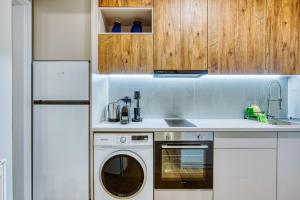 a kitchen with a washing machine and a refrigerator at Modern City Studio with Balcony Columbus Apartment in Chios