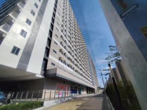 a tall white building next to a street at Naomi's Green Haven in Dasmariñas