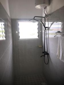 a shower in a bathroom with a window at Alberjah Hotel in Atimpoko
