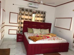 a bedroom with a large red bed in a room at Alberjah Hotel in Atimpoko +2 photos