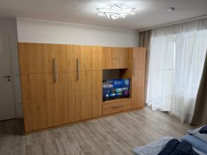 a large wooden cabinet with a television in a room at Pension Holter Deel in Cuxhaven