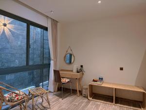 a room with a bed and a desk and a window at Mom Villa - Cẩm Thanh in Hiếu Nhơn