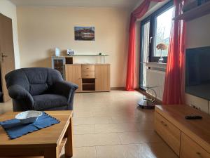 a living room with a chair and a tv at Ferienwohnung "Casa Horife" in Konz