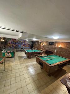 a room with ping pong tables and graffiti on the walls at Fenyves fogadó in Ásotthalom
