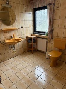 a bathroom with a sink and a toilet and a window at Ferienwohnung "Casa Horife" in Konz +8 photos
