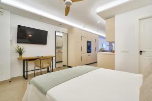 a bedroom with a bed and a desk and a tv at Malagueta Loft & Sea in Málaga
