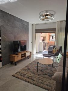 a living room with a tv and a couch and a table at Lassa Holiday Apartament in Torrevieja