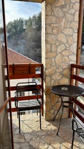 a balcony with a table and chairs and a stone wall at Hotel Veronika Devin in Devin