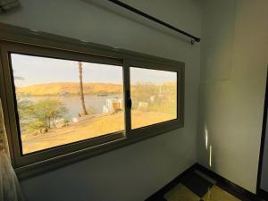 a room with a window with a view of a lake at Bayt Zaina Nile View in Aswan