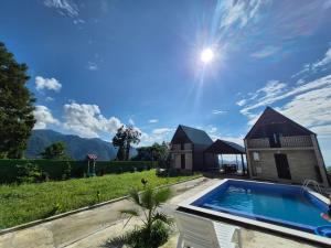 a villa with a swimming pool and a house at Close to the sky in Agara