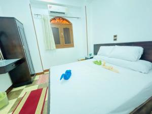 a bedroom with a bed with two birds sitting on it at Bayt Zaina Nile View in Aswan