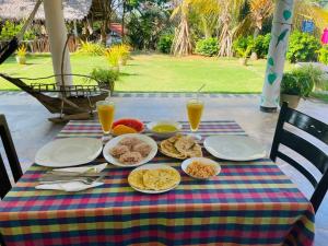 a table with plates of food and drinks on it at Screwpine Beach Villa in Hiriketiya