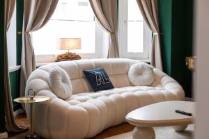 a living room with a white couch in front of a window at Emerald Suite Design in Neumünster in Neumünster
