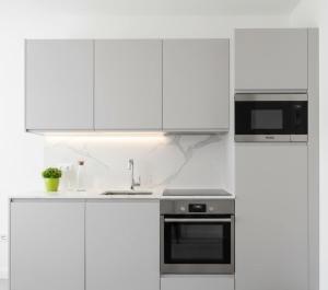 a white kitchen with a sink and a microwave at hayal hotel in Tokat