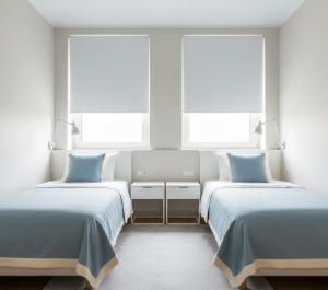 two beds in a room with two windows at hayal hotel in Tokat +12 photos