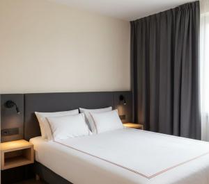 a bedroom with a large bed with white sheets at hayal hotel in Tokat