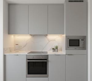 a white kitchen with a stove and a microwave at hayal hotel in Tokat