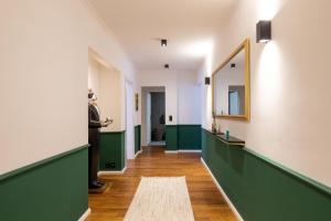 a hallway with green and white walls and a mirror at Emerald Suite Design in Neumünster in Neumünster